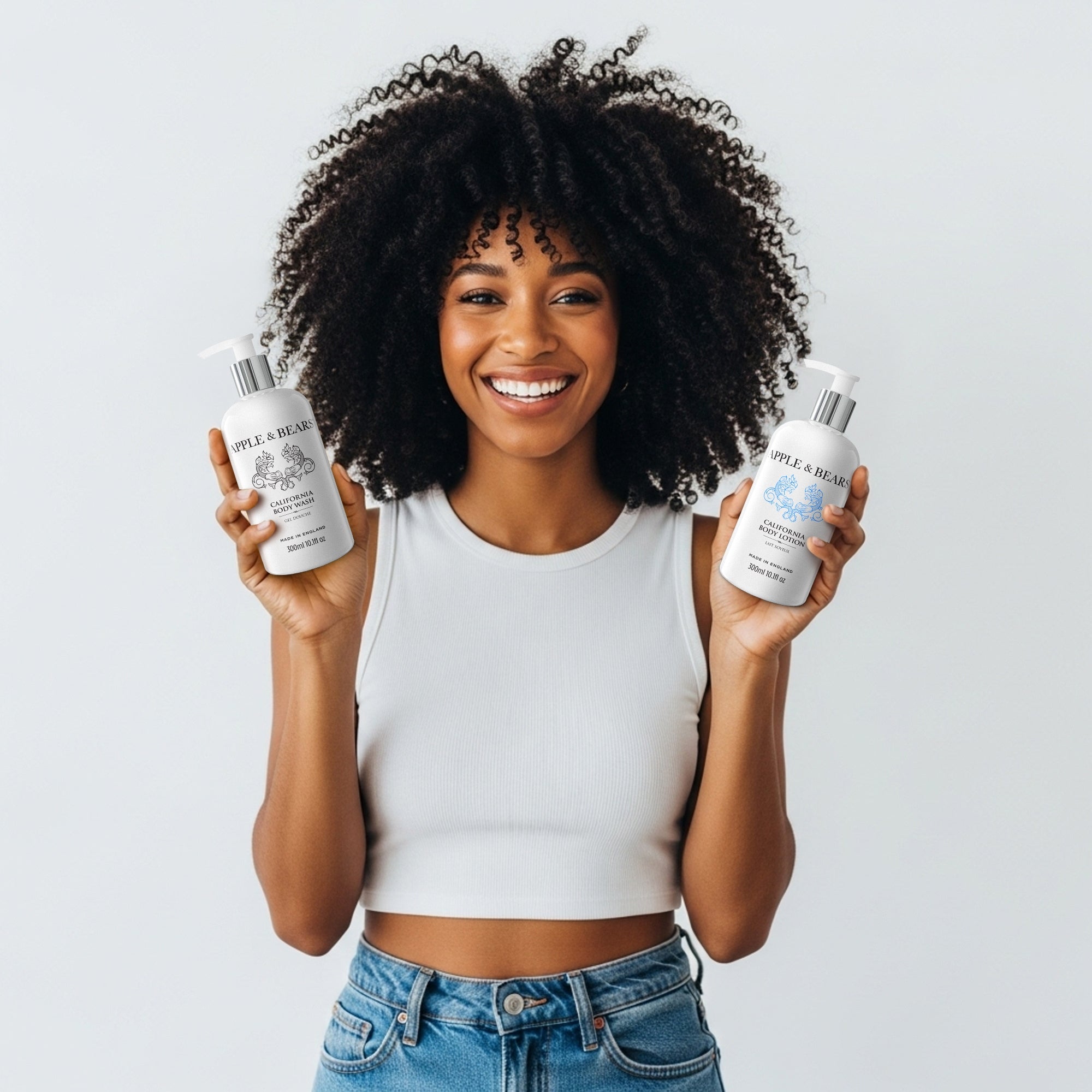 Apple & Bears California Luxury Skincare Duo - Energising citrus body wash and lotion held by model, featuring natural UK-made ingredients for a zesty morning routine.