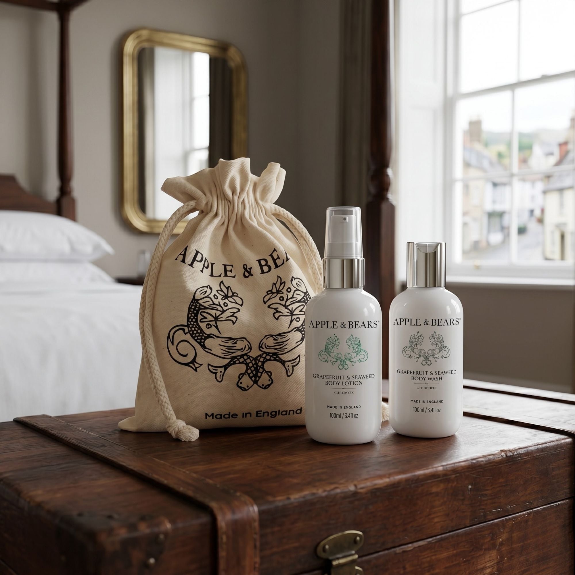 Apple & Bears Grapefruit and Seaweed Body Lotion and Body Wash 100ml with eco cotton drawstring bag Made in England on antique trunk in boutique hotel bedroom