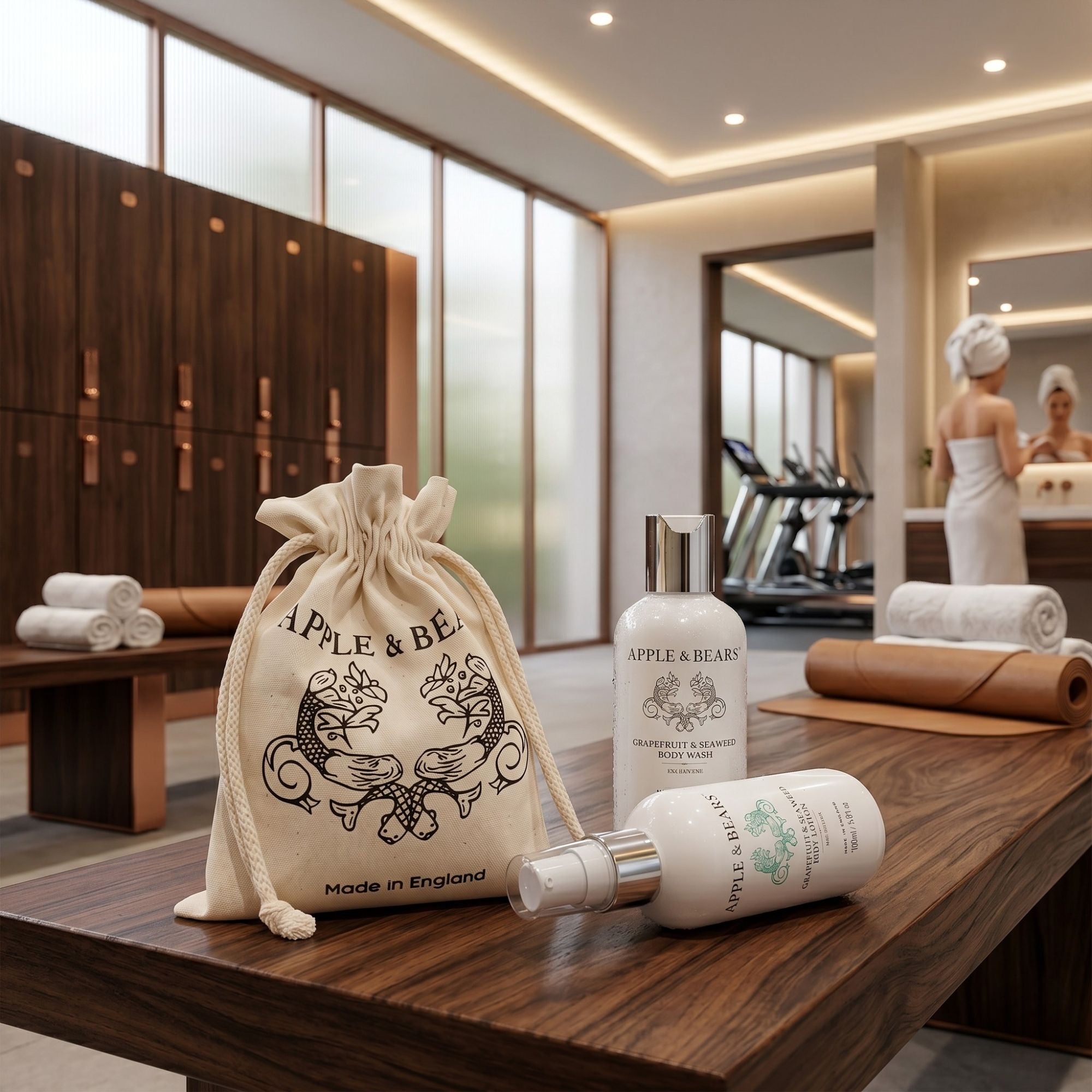 Apple & Bears Grapefruit and Seaweed Body Wash and Body Lotion 100ml with eco cotton drawstring bag Made in England on wooden bench in luxury gym changing room