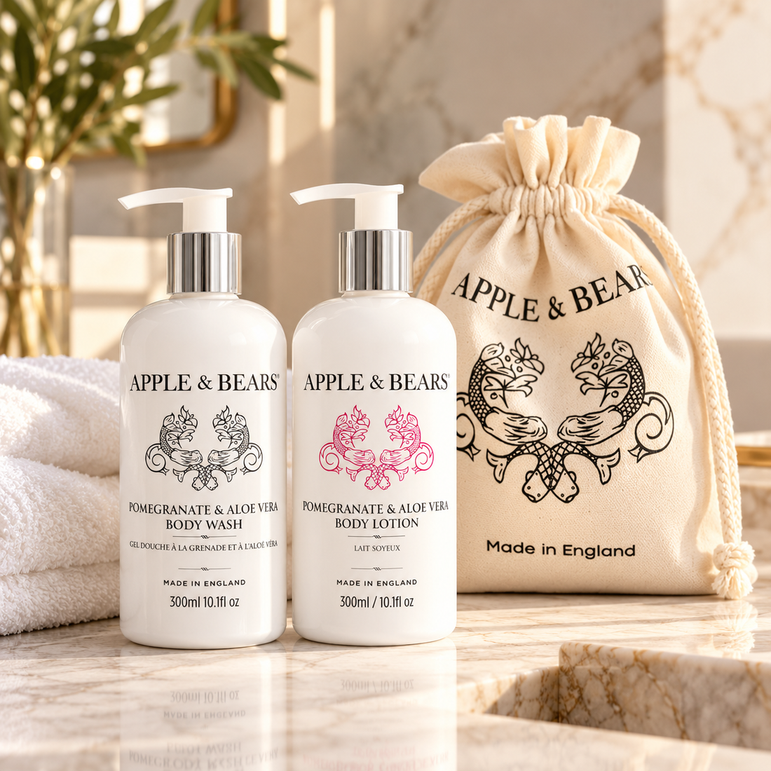 APPLE & BEARS Pomegranate & Aloe Vera luxury body care gift set featuring 300ml Body Wash and Body Lotion with reusable cotton gift bag, displayed in an elegant bathroom. Made in England.