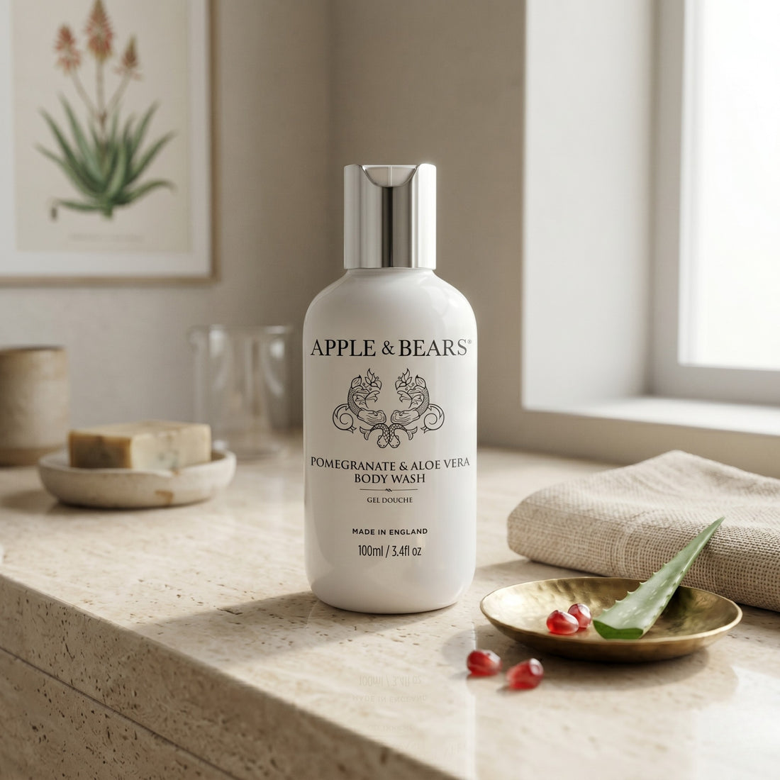 Apple & Bears Pomegranate & Aloe Vera Body Wash 100ml on stone plinth with fresh pomegranate and aloe vera, made in England