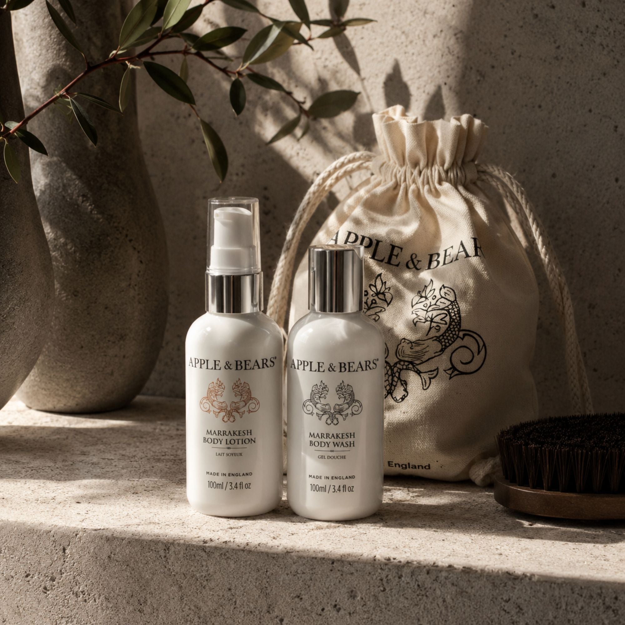 Apple & Bears Marrakesh Travel Gift Set 100ml/3.4 fl oz with eco cotton drawstring bag on concrete ledge with olive branch in Moroccan riad, Made in England