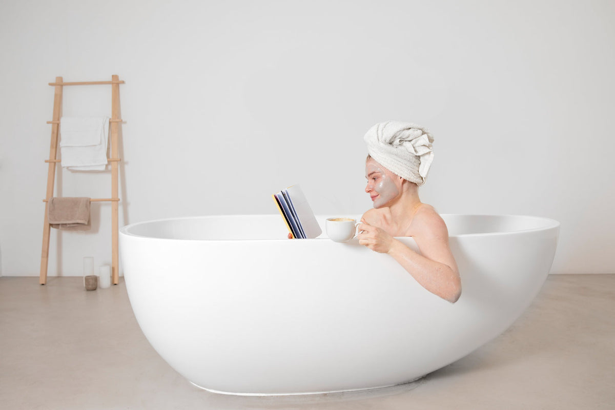A luxury bathroom setting with a woman relaxing in a bathtub, featuring Apple & Bears Vitamin C body care