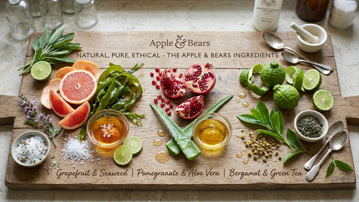 Apple & Bears luxury skincare ingredients including Pomegranate, Aloe Vera, Grapefruit, Seaweed, and Bergamot on a natural wooden board.
