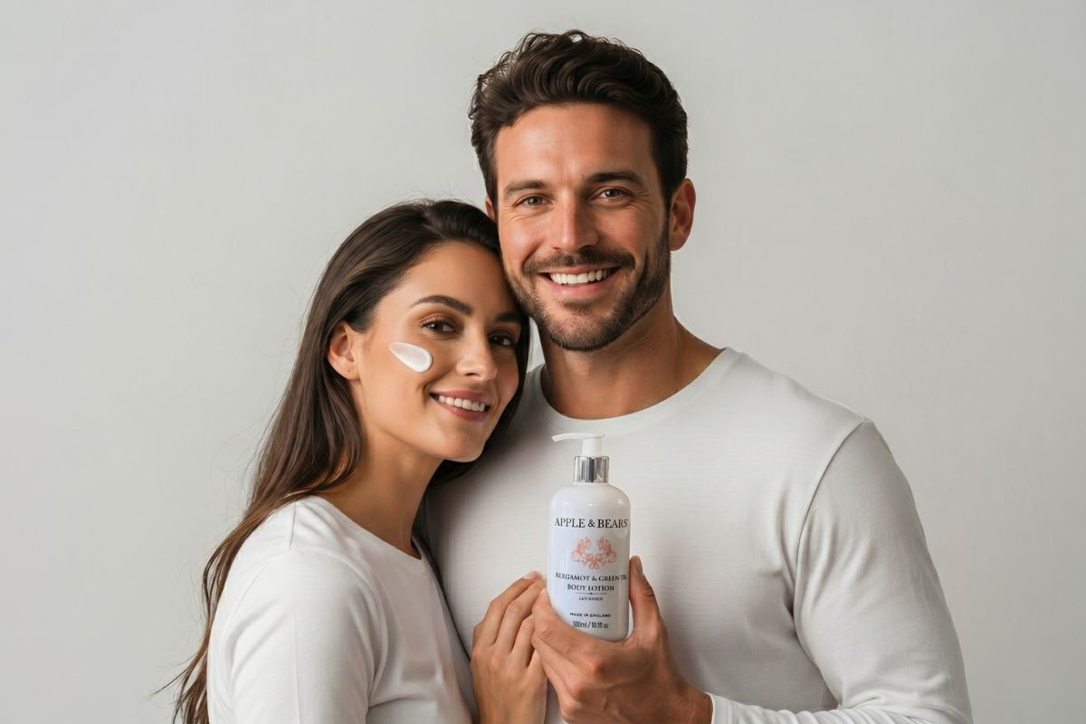 Smiling couple in white holding Apple & Bears Bergamot & Green Tea Body Lotion 300ml with lotion applied to cheek — natural sulphate-free body lotion made in England.