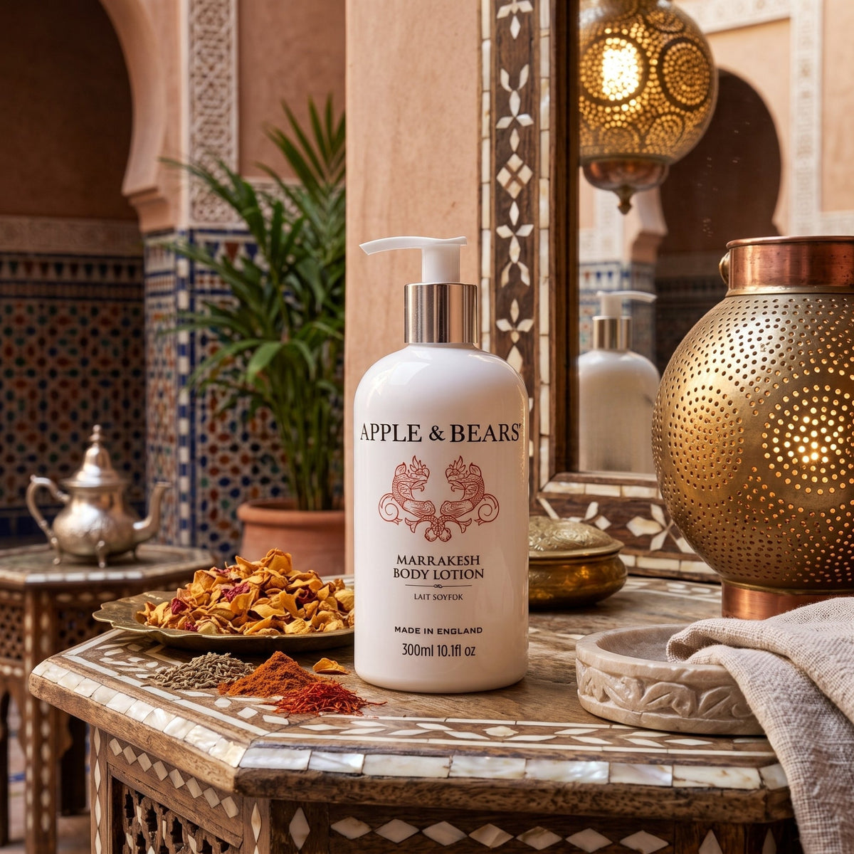Apple & Bears Marrakesh Body Lotion 300ml on a mosaic table in a Moroccan riad setting with dried spices, rose petals and a brass lantern — natural vegan body lotion made in England