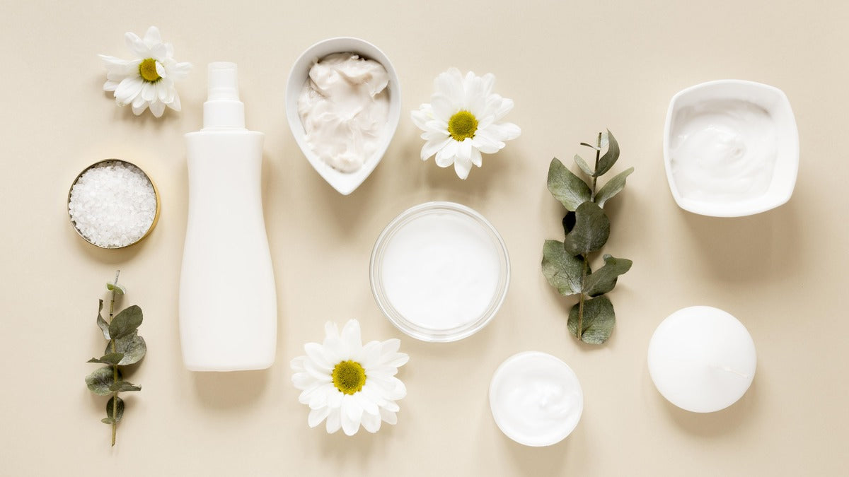 luxury skincare products, including body lotion and body wash bottles, surrounded by green leaves