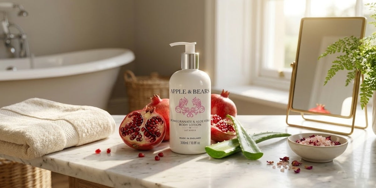APPLE & BEARS Pomegranate & Aloe Vera Body Lotion 300ml on a marble surface with fresh pomegranate and aloe vera — natural, conditioning body lotion made in England.