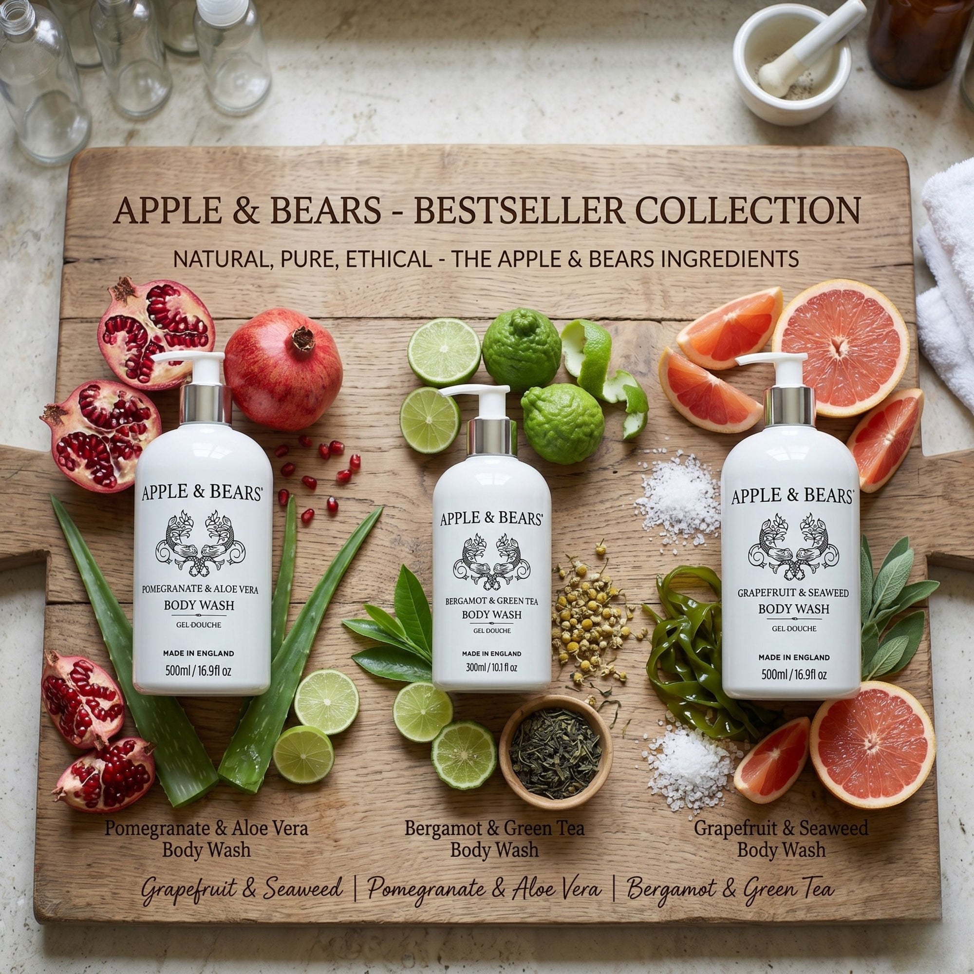 Apple &amp; Bears Bestseller Collection — Pomegranate &amp; Aloe Vera, Bergamot &amp; Green Tea, and Grapefruit &amp; Seaweed Body Wash bottles displayed on a wooden board with fresh natural ingredients, Made in England