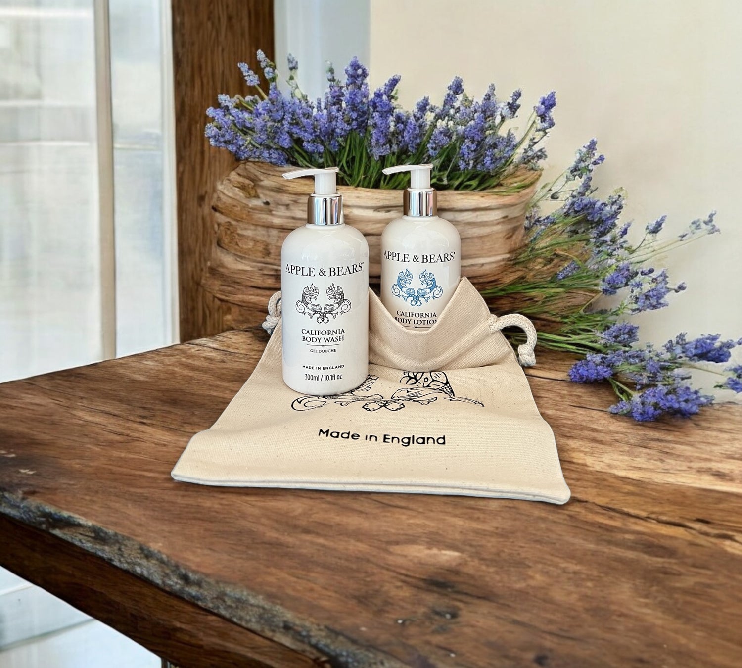 California Luxury Body Care Gift Set - Natural citrus body wash and lotion displayed on a rustic wooden surface with floral accents by Apple &amp; Bears.
