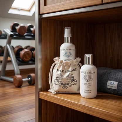 Apple &amp; Bears California Body Wash and Lotion 100ml with eco cotton branded drawstring bag on wooden gym shelf with dumbbells - natural body care for active lifestyles