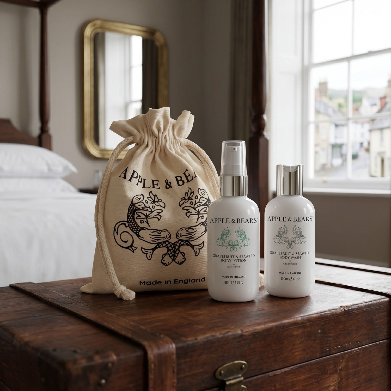 Apple &amp; Bears Grapefruit and Seaweed Body Lotion and Body Wash 100ml with eco cotton drawstring bag Made in England on antique trunk in boutique hotel bedroom