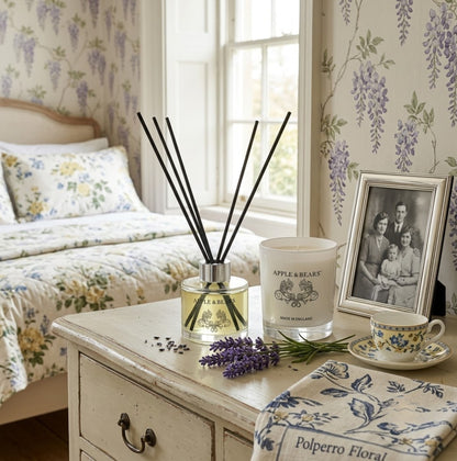 Apple &amp; Bears Lavender Home Fragrance Gift Set with Reed Diffuser and Soy Wax Candle on a painted vintage bedside table with fresh lavender sprigs, vintage family portrait and English bone china teacup in a country bedroom with wisteria wallpaper, Made in England
