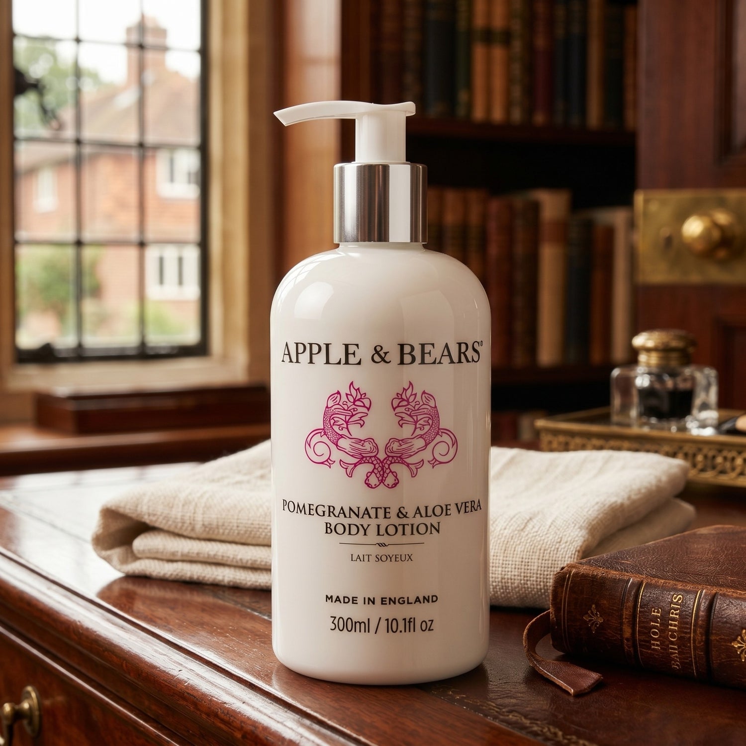 Apple and Bears Pomegranate and Aloe Vera Body Lotion 300ml on mahogany dresser beside linen towel and leather book country house lifestyle made in England