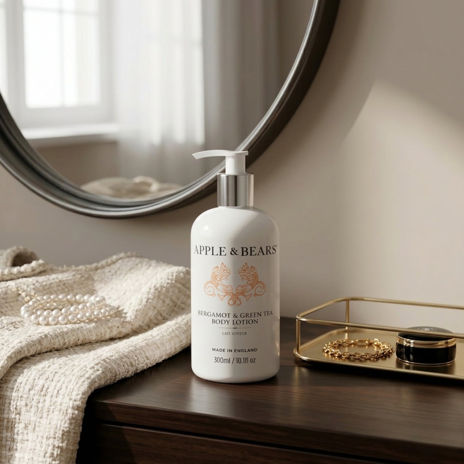 Apple &amp; Bears Bergamot &amp; Green Tea Body Lotion 300ml on a bedside table with pearls and gold jewellery tray in a luxury bedroom
