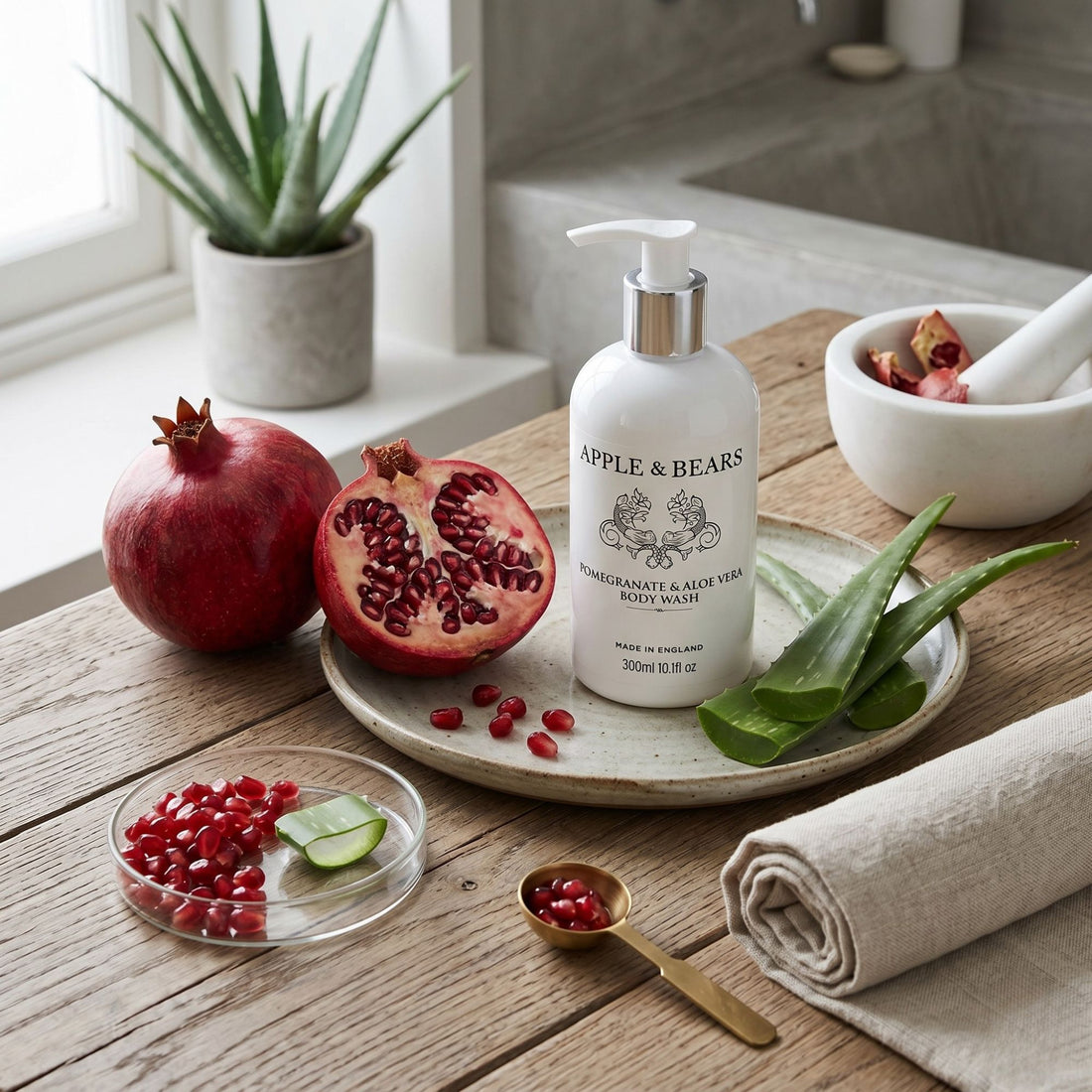 Pomegranate &amp; Aloe Vera Body Wash 300ml by Apple &amp; Bears with fresh pomegranate and aloe vera on rustic wood