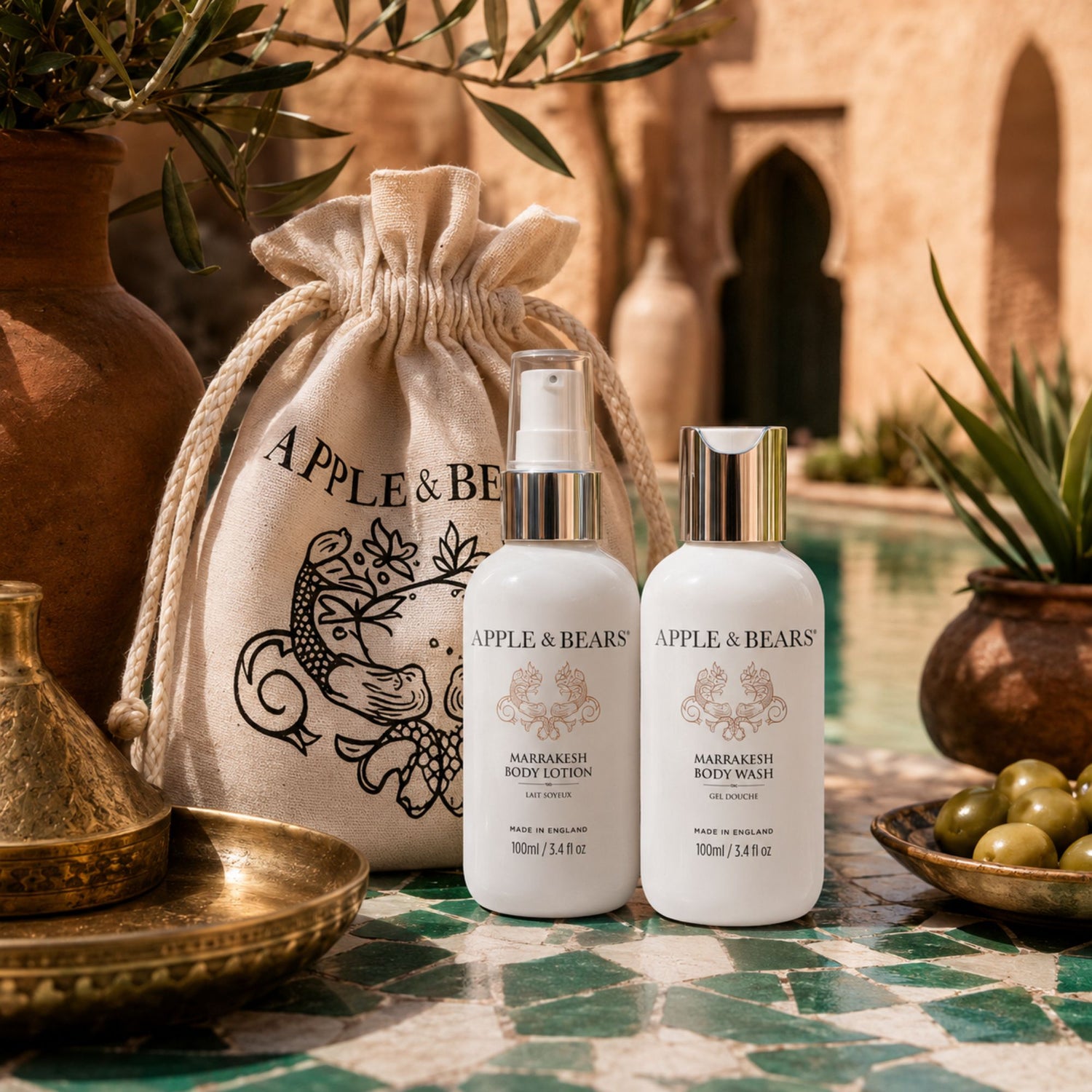 Apple &amp; Bears Marrakesh Body Lotion &amp; Body Wash Travel Gift Set 100ml/3.4 fl oz on ornate brass tray with Moroccan cushions and riad pool, Made in England
